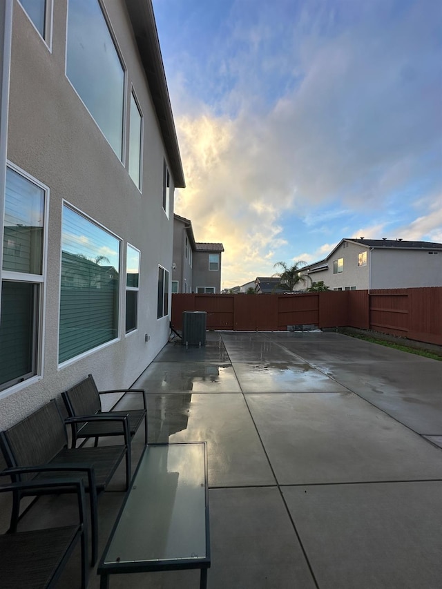 patio terrace at dusk featuring central AC unit