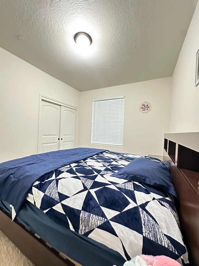 bedroom featuring a textured ceiling and a closet