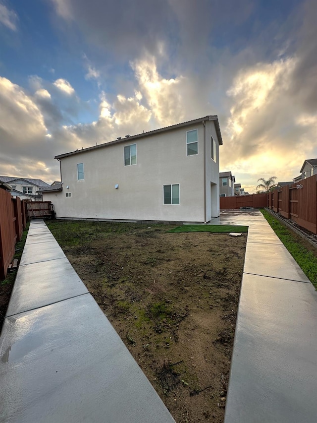 property exterior at dusk featuring a patio