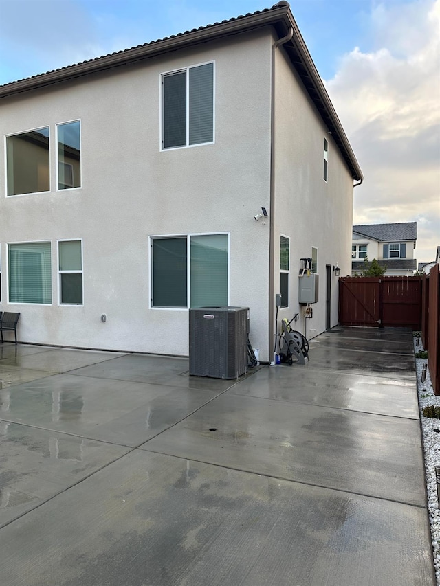 back of house with cooling unit and a patio