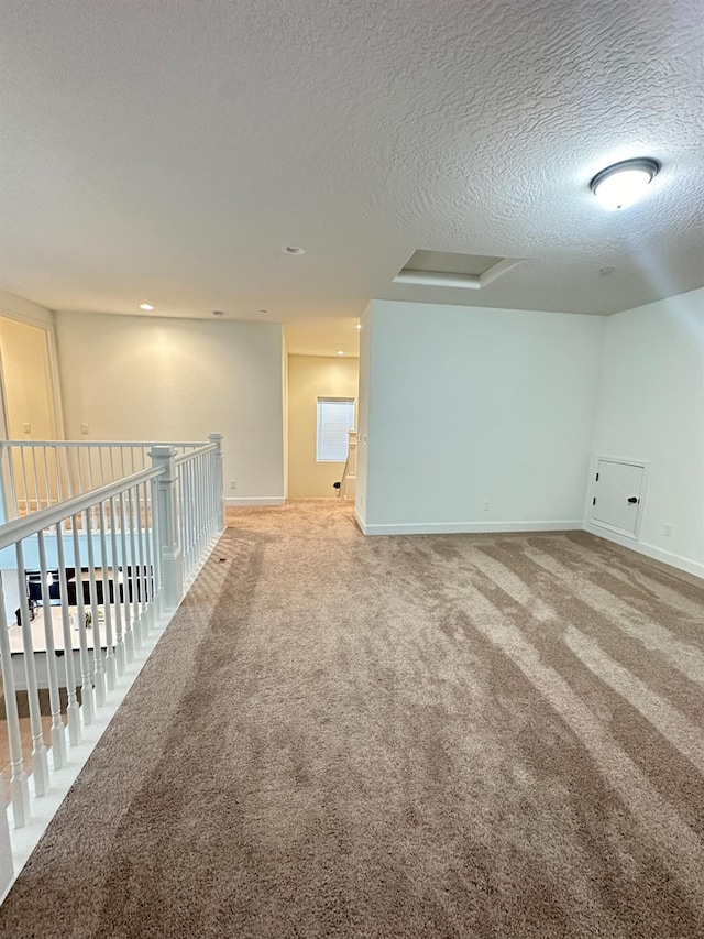 carpeted empty room with a textured ceiling