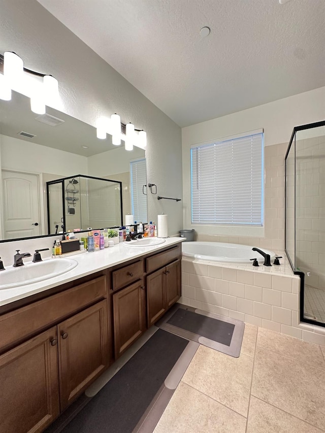 bathroom with tile patterned flooring, vanity, shower with separate bathtub, and a textured ceiling