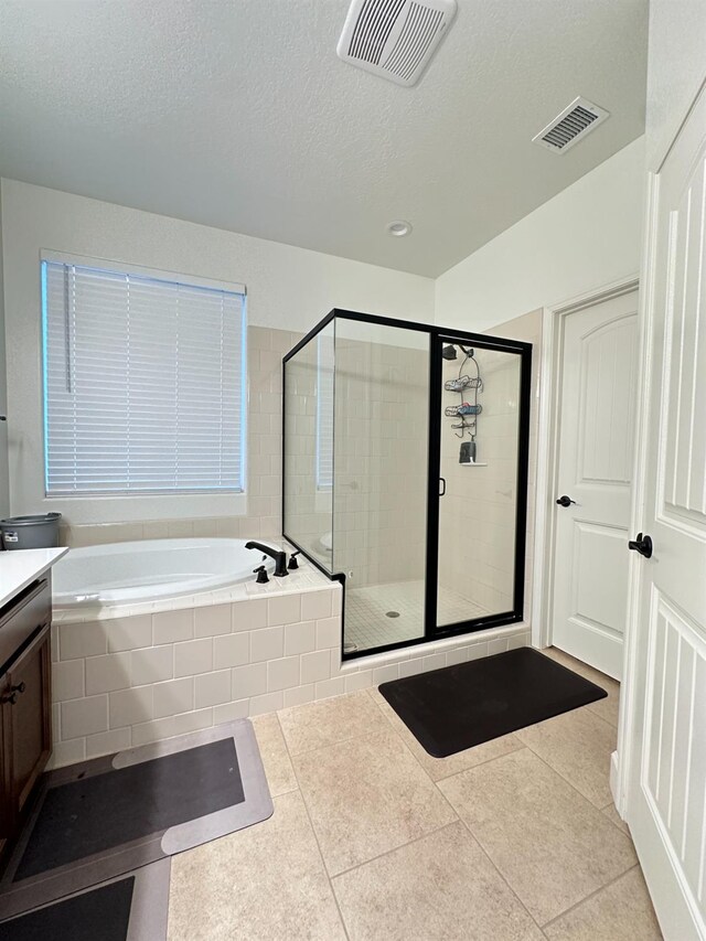 bathroom featuring separate shower and tub, tile patterned floors, vanity, and a textured ceiling