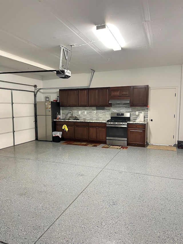 garage with stainless steel fridge, sink, and a garage door opener