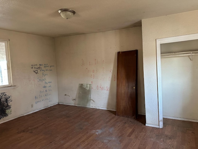 unfurnished bedroom featuring dark hardwood / wood-style floors and a closet