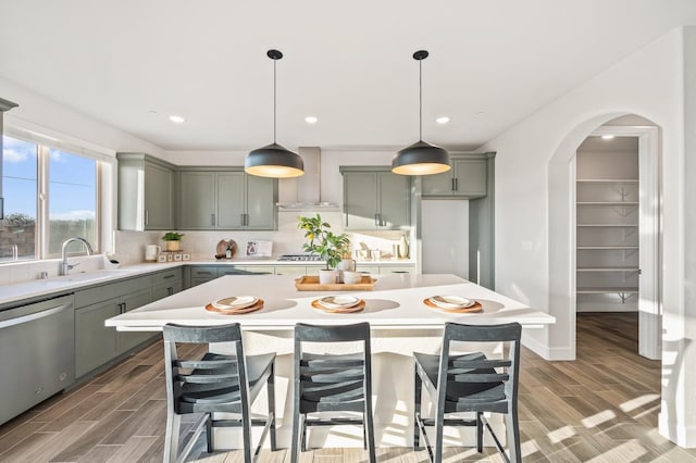 946 Talus Way S, Madera, CA 93636 - kitchen with dishwasher, wall chimney range hood, arched walkways, backsplash, and light wood-type flooring