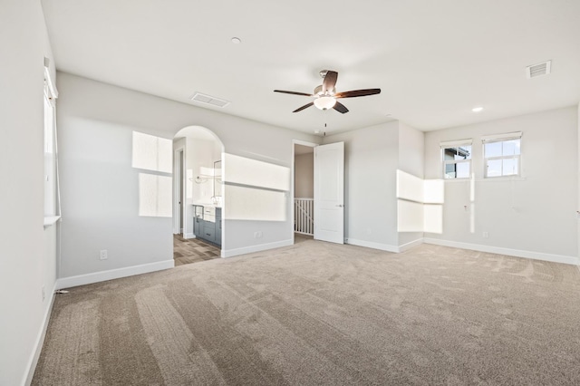 946 Talus Way S, Madera, CA 93636 - unfurnished bedroom featuring light colored carpet, arched walkways, ensuite bathroom, and recessed lighting
