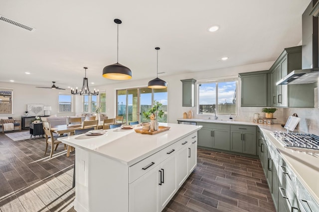 946 Talus Way S, Madera, CA 93636 - kitchen featuring stainless steel gas stovetop, wall chimney range hood, recessed lighting, plenty of natural light, and light countertops