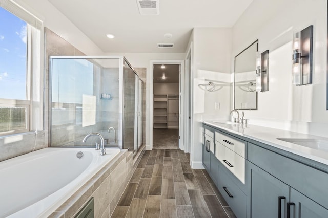 bathroom with vanity and shower with separate bathtub