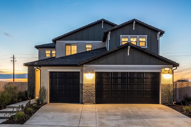 946 Talus Way S, Madera, CA 93636 - view of front facade featuring an attached garage, a tiled roof, driveway, stone siding, and board and batten siding