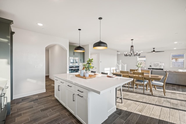 946 Talus Way S, Madera, CA 93636 - kitchen featuring stainless steel appliances, arched walkways, wood tiled floors, a ceiling fan, and a kitchen island