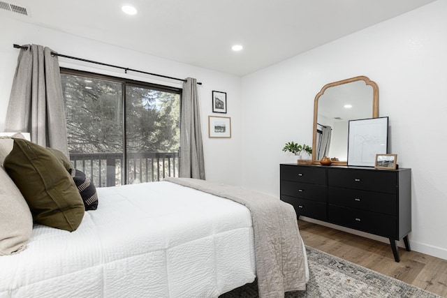 bedroom featuring access to exterior and hardwood / wood-style flooring