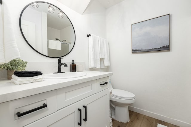 bathroom featuring vanity, hardwood / wood-style flooring, and toilet