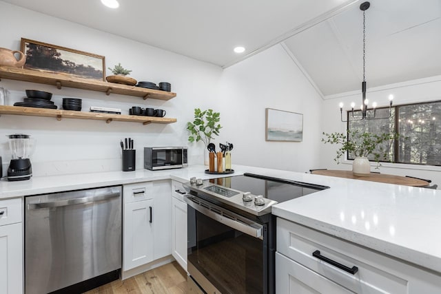 kitchen with a chandelier, appliances with stainless steel finishes, white cabinetry, and hanging light fixtures