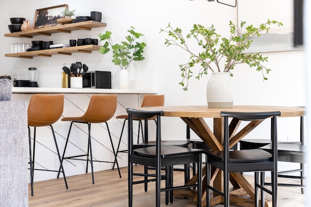 bar with light hardwood / wood-style flooring