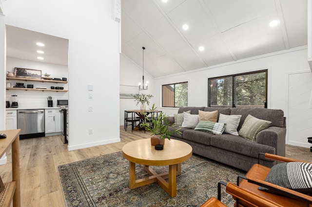 living room featuring lofted ceiling, a notable chandelier, and light wood-type flooring