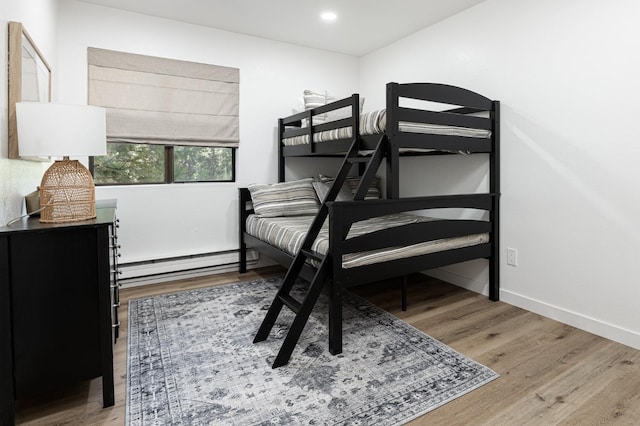 bedroom featuring a baseboard radiator and light hardwood / wood-style floors