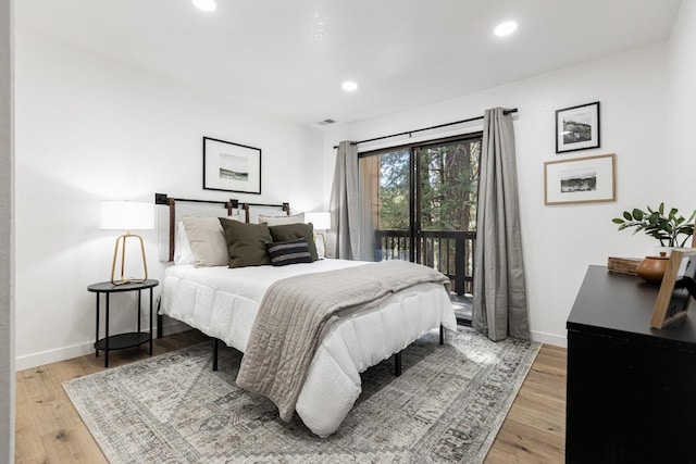 bedroom featuring access to exterior and light wood-type flooring