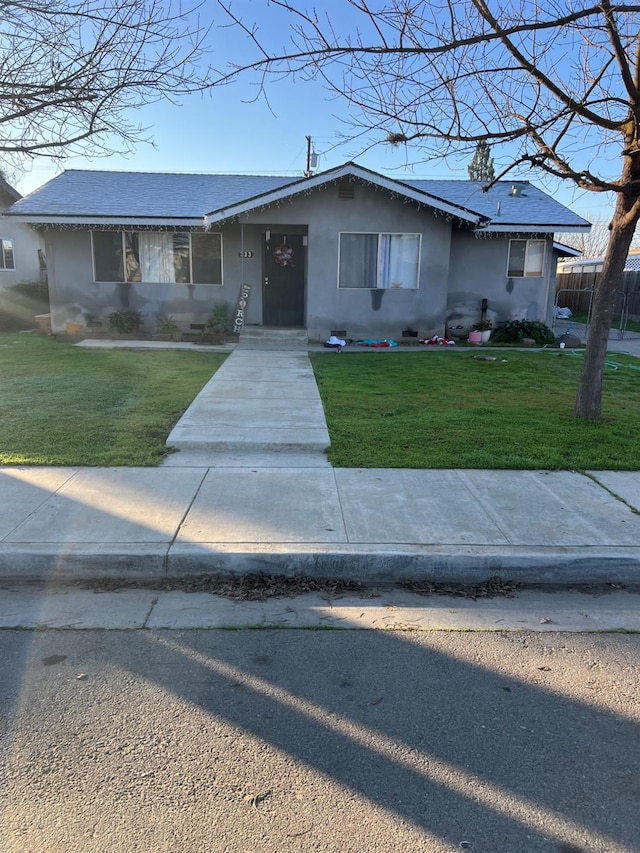 ranch-style home featuring a front lawn