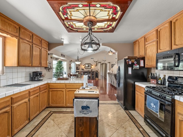 28899 Limestone Way, Coarsegold, CA 93614 - kitchen with black appliances, a peninsula, ceiling fan, tasteful backsplash, and vaulted ceiling