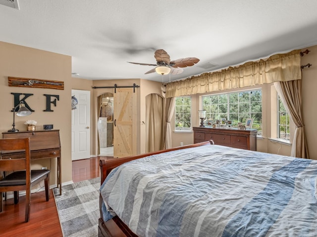 28899 Limestone Way, Coarsegold, CA 93614 - bedroom featuring a barn door, wood finished floors, baseboards, and ceiling fan