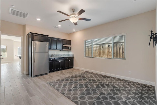 kitchen featuring ceiling fan, light hardwood / wood-style flooring, and appliances with stainless steel finishes