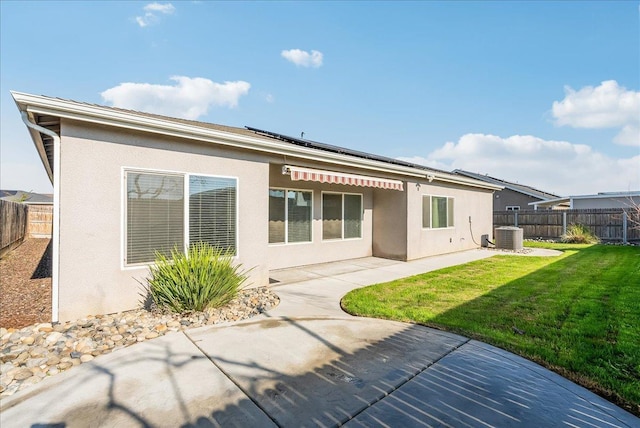 back of house with a patio area, a yard, and central air condition unit