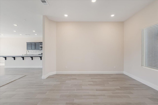 empty room with light hardwood / wood-style floors and sink