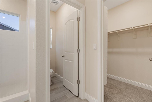 bathroom with walk in shower and toilet