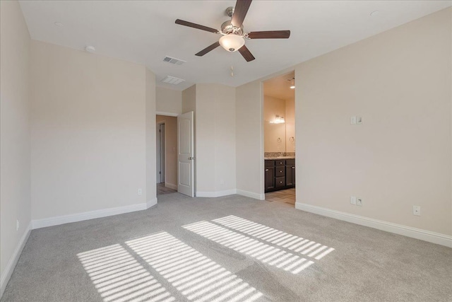 unfurnished bedroom featuring ensuite bathroom, ceiling fan, and light carpet