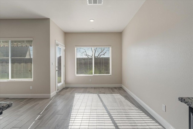 empty room with light hardwood / wood-style flooring