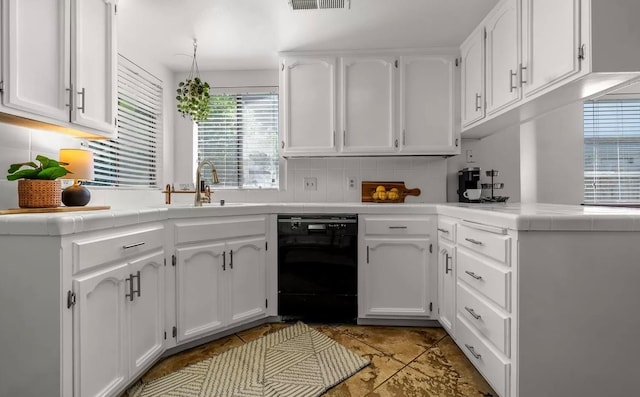 kitchen featuring black dishwasher, tile countertops, white cabinetry, and decorative backsplash