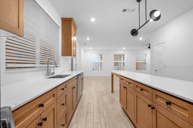 kitchen with sink, ceiling fan, light hardwood / wood-style floors, stainless steel dishwasher, and pendant lighting