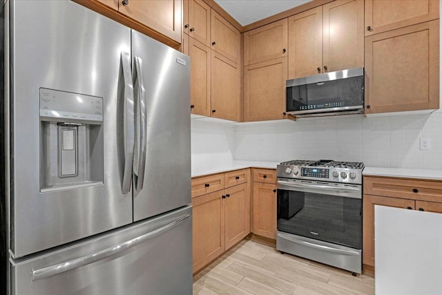 kitchen with stainless steel appliances, light wood-type flooring, and backsplash