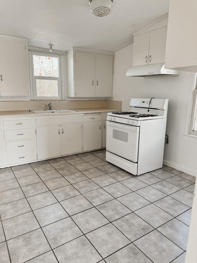 kitchen with light tile patterned floors, a textured ceiling, sink, white cabinetry, and white gas range