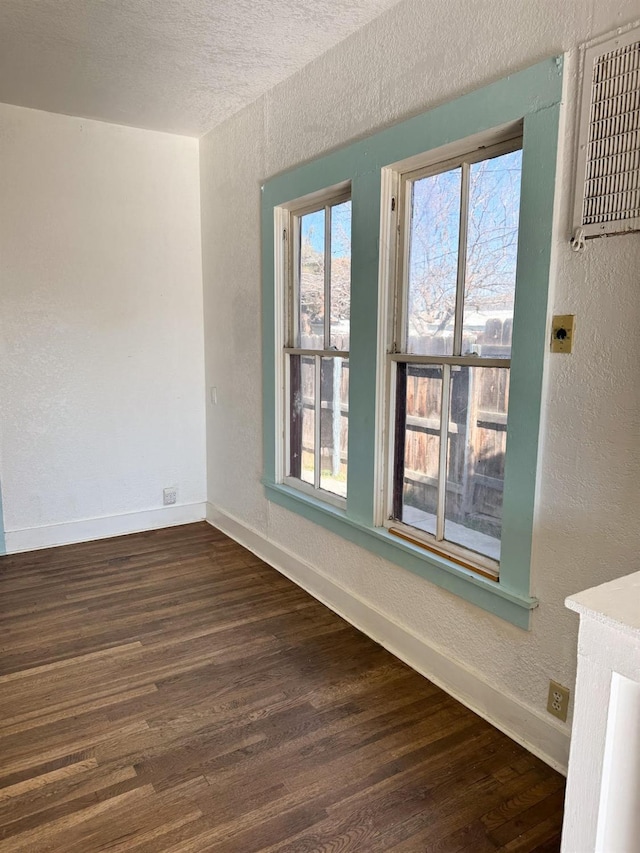 unfurnished room featuring a textured ceiling and dark wood-type flooring