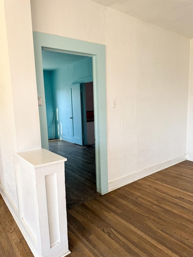 corridor with dark hardwood / wood-style flooring