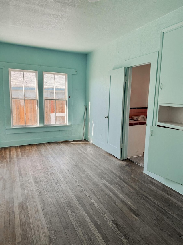 empty room with a textured ceiling and hardwood / wood-style floors