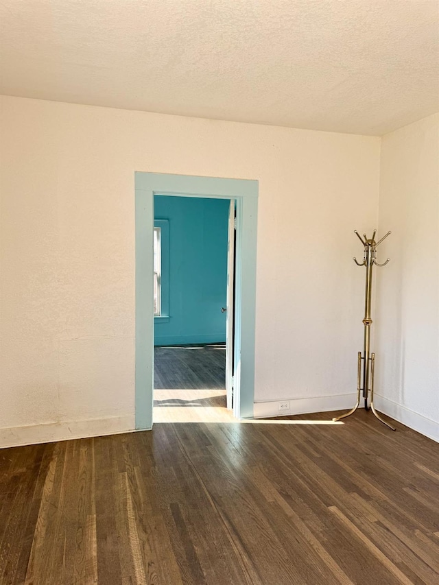 spare room featuring a textured ceiling and wood-type flooring