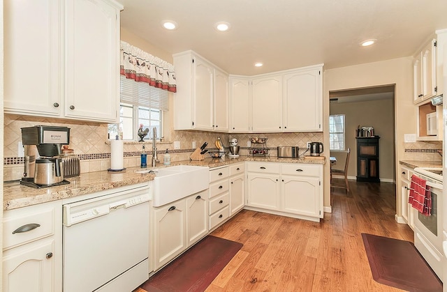 kitchen with light wood-type flooring, white appliances, white cabinetry, and sink