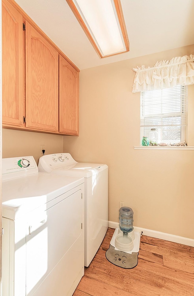 washroom featuring cabinets, light wood-type flooring, and washing machine and dryer