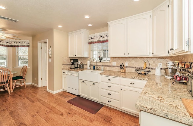 kitchen featuring dishwasher, white cabinetry, and sink