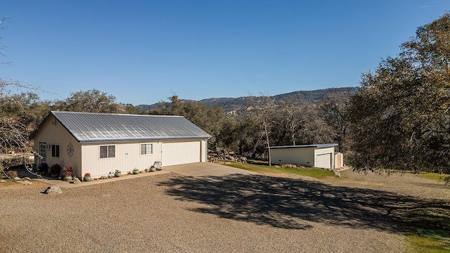 view of front of house featuring a mountain view and an outdoor structure