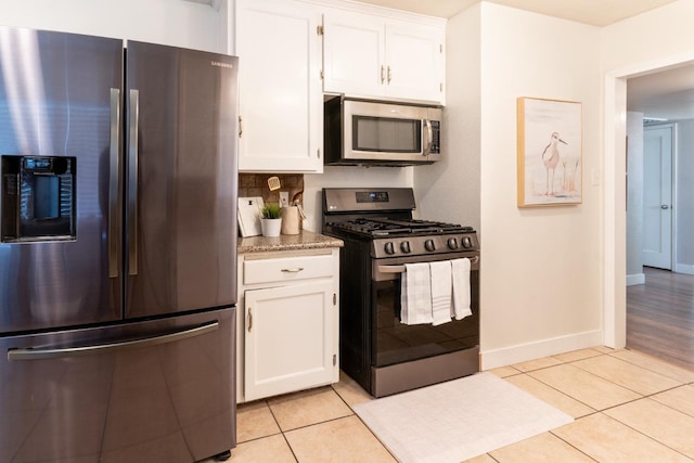 kitchen featuring decorative backsplash, appliances with stainless steel finishes, light tile patterned floors, and white cabinetry