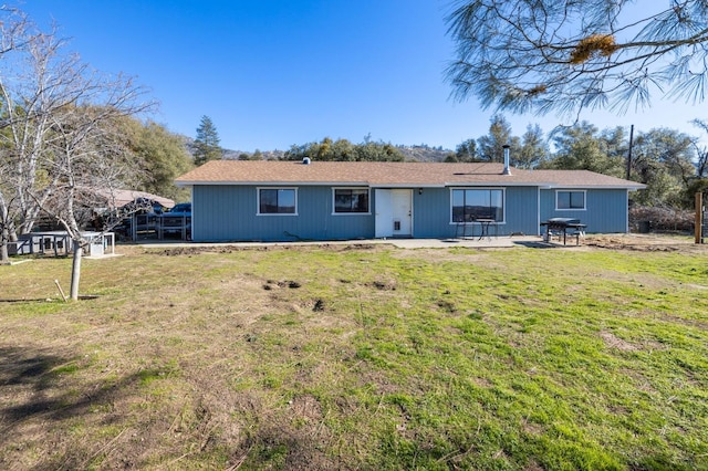 rear view of property with a lawn and a patio