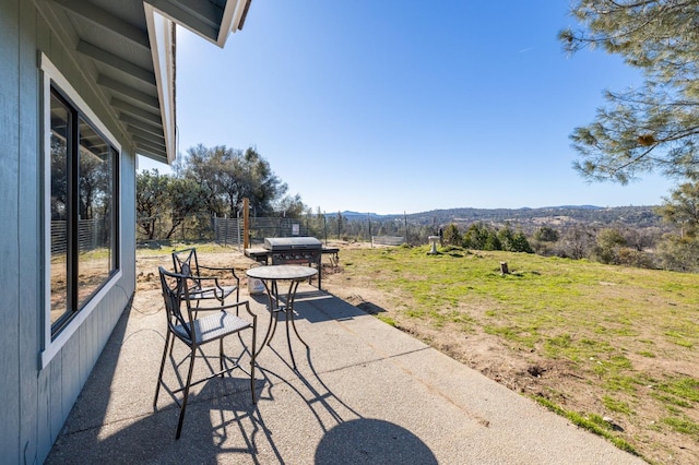 view of patio featuring fence and a mountain view