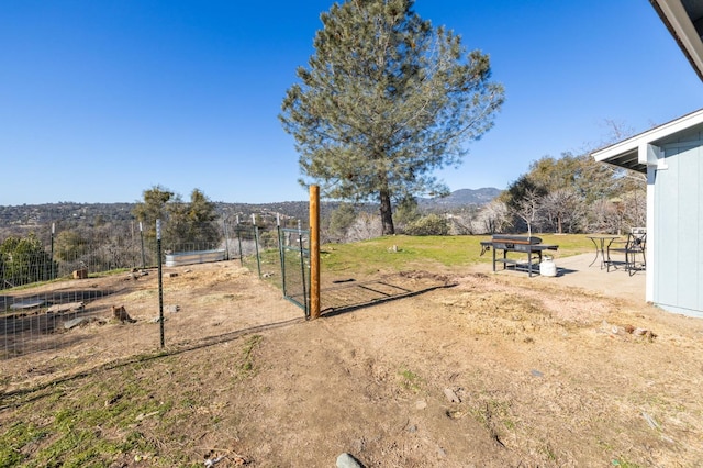 view of yard with a gate, a mountain view, and fence