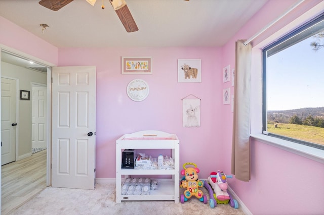 recreation room featuring ceiling fan and baseboards