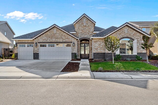 french country inspired facade featuring a garage