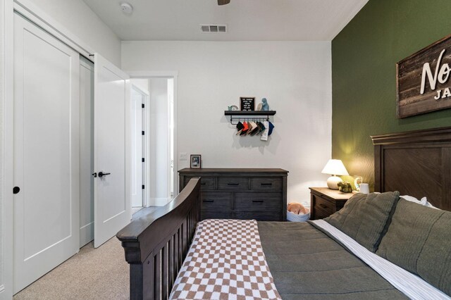 bedroom with light colored carpet and a closet